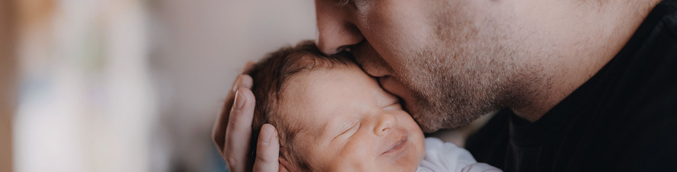 homme embrassant un bébé