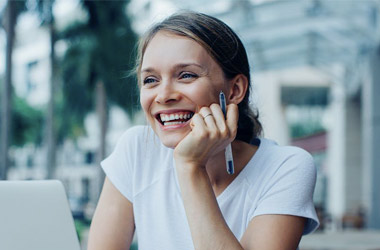 Photographie d'une femme souriante devant un bureau