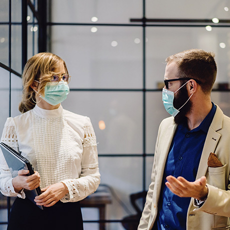 Un homme et une femme masqués dans un bureau