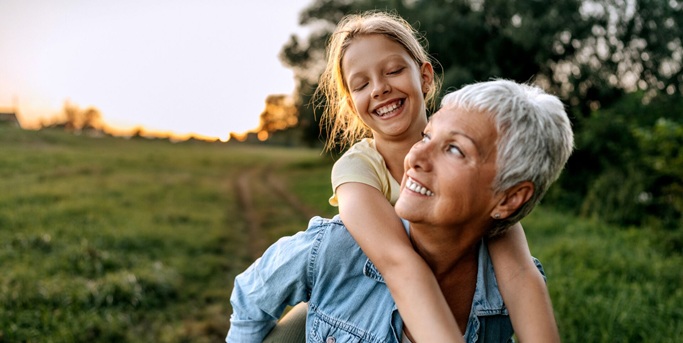 Grand-parents se promenant dans la nature avec leur petit-fils sur les épaules du grand-père
