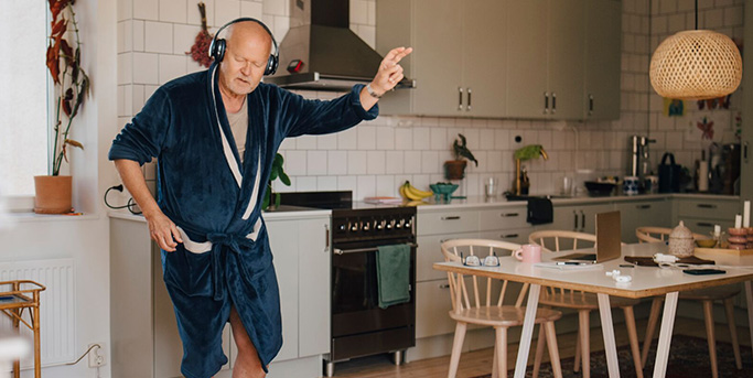 Senior écoutant de la musique dans sa cuisine 683 343