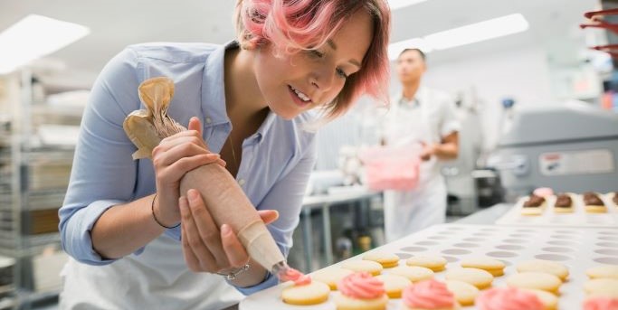 Jeune femme préparant des gâteaux