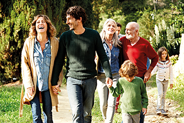 Happy multi-generation family holding hands while walking in park