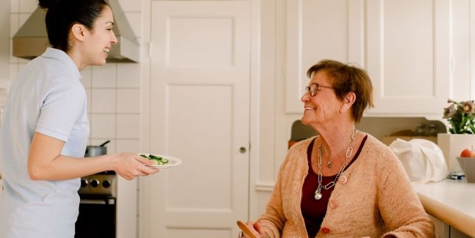 Aide soignant apportant un repas