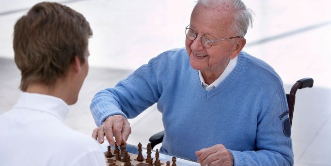 Senior en fauteuil joue aux echecs