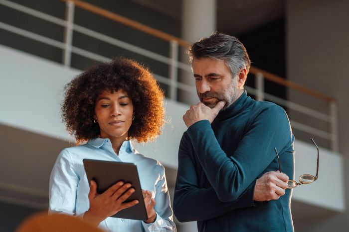 Homme et femme regardent tablette au travail