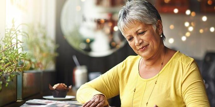 1280 Web Femme qui lit son journal dans un café