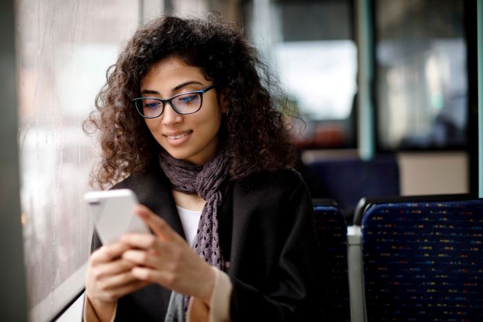 Jeune femme dans les transport en commun avec un smartphone