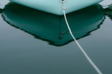 little rowboat and reflection on quiet water on the sea.  