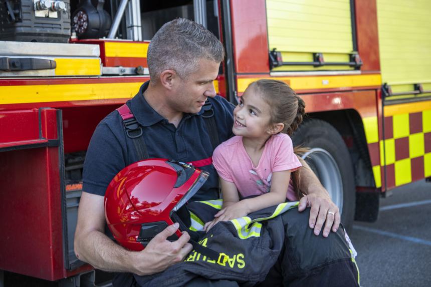 Pompier avec une petite fille dans ses bras